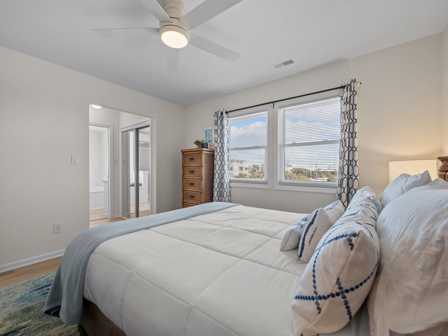 Drift off to sleep in your serene bedroom, where soft linens and a gentle ceiling fan create the perfect sanctuary for restful nights.