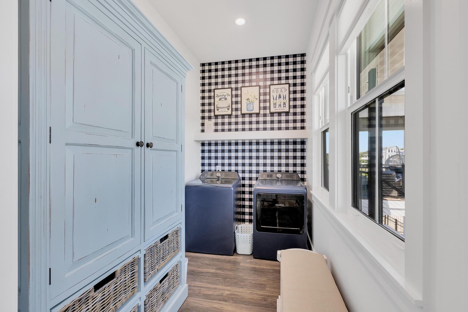This charming laundry room keeps chores light with cheerful gingham accents, classic farmhouse decor, and ample storage to make your stay effortless.