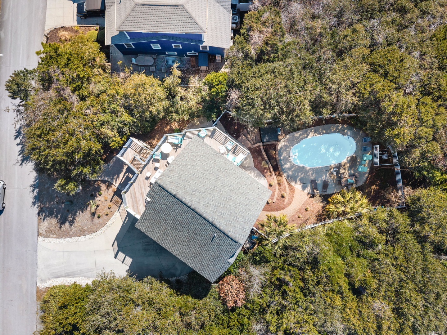 Aerial view showcases the property nestled among mature trees with a private swimming pool and spacious outdoor areas for relaxation.
