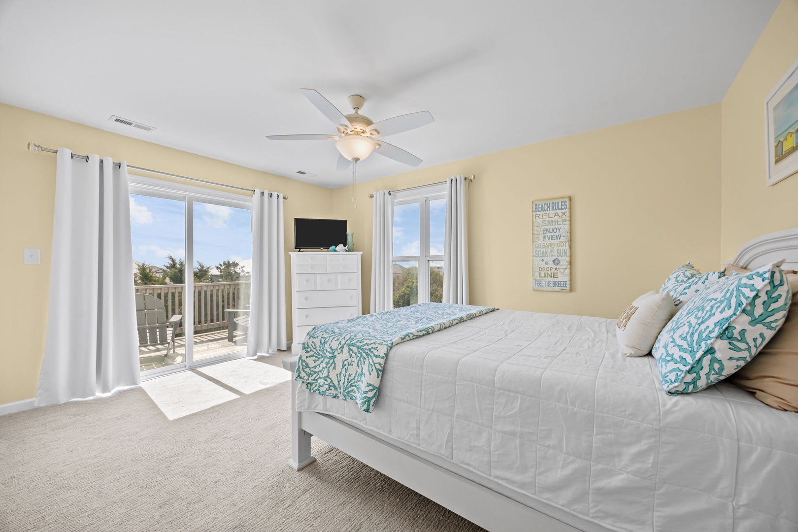 Wake up to ocean breezes in your coastal bedroom, where coral-patterned linens and balcony access create your perfect beach retreat.