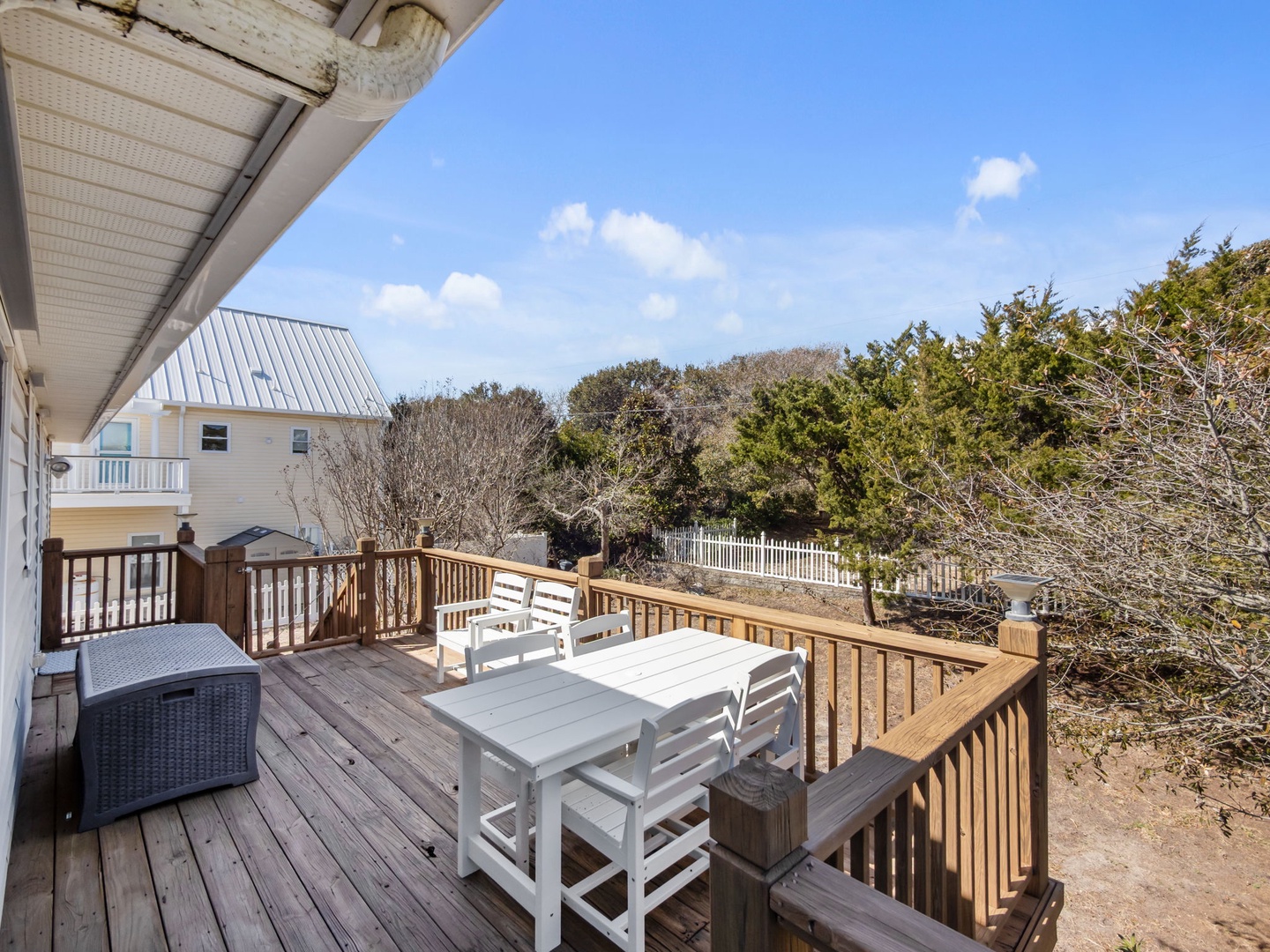 Step onto your private deck and savor peaceful moments at the outdoor dining table, surrounded by coastal charm and blue skies.