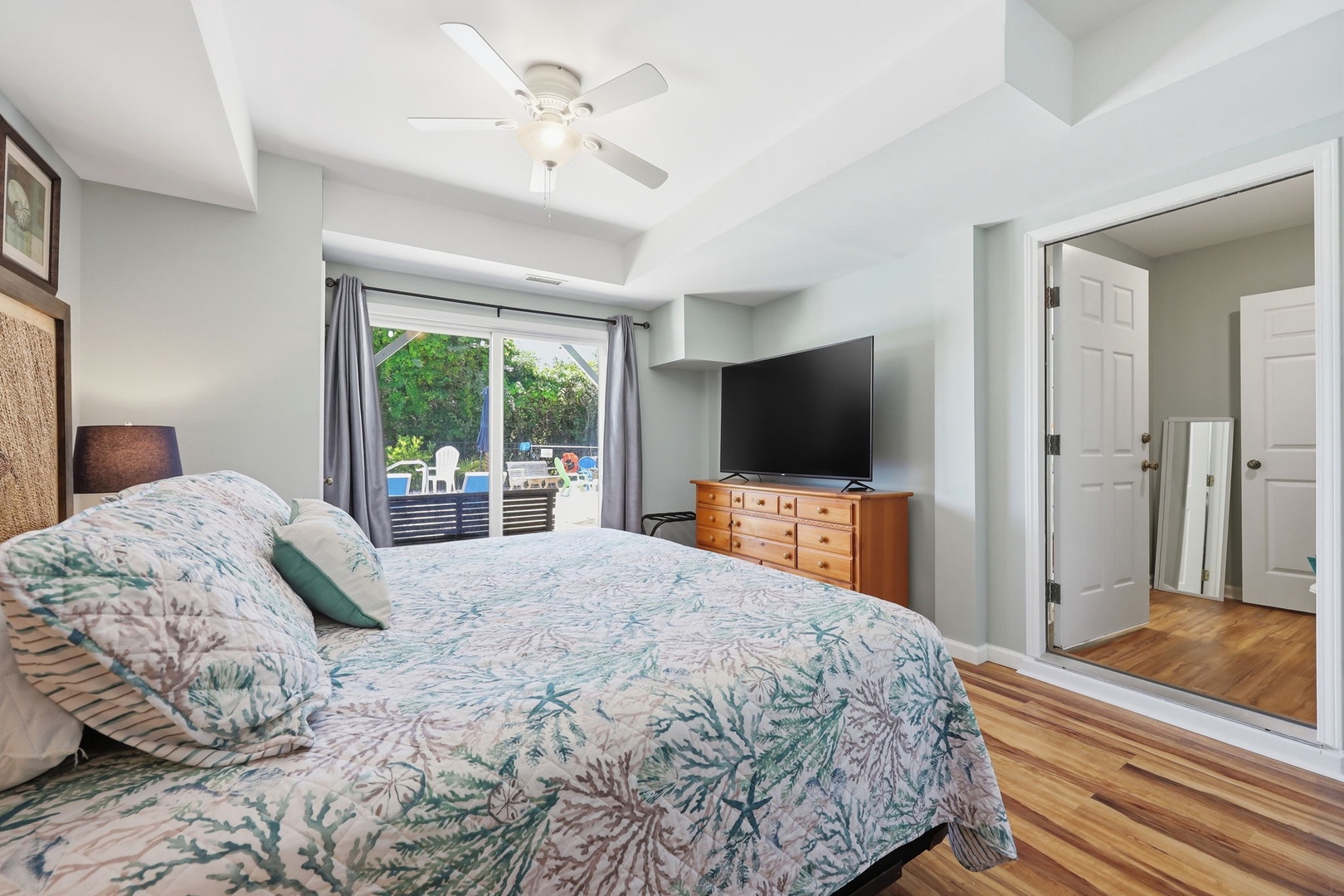 Wake up to bright mornings in your serene bedroom, where coastal-inspired bedding and gleaming hardwood floors create a calming retreat. Step outside to your private patio access for morning coffee.