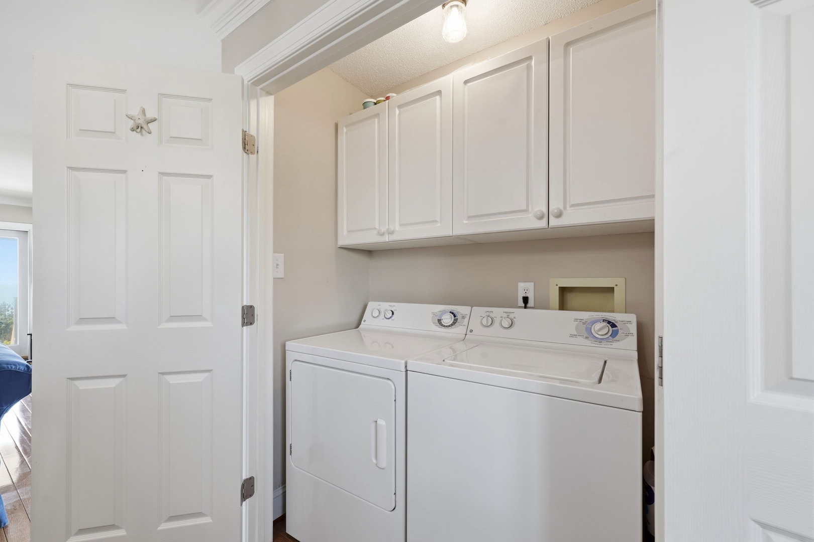 Your vacation laundry is effortlessly handled in this bright, dedicated space with a full-sized washer and dryer, plus plenty of overhead storage to keep everything tidy.