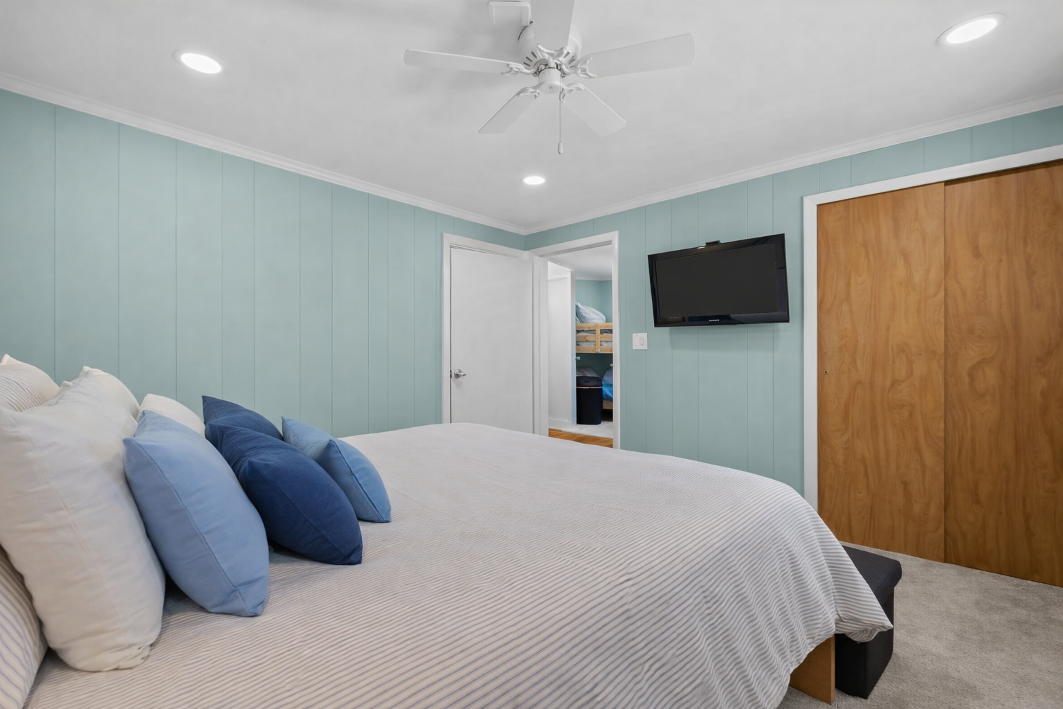 Your coastal retreat features soft blue accents and crisp linens, with gentle ceiling fan breezes keeping you comfortable year-round.
