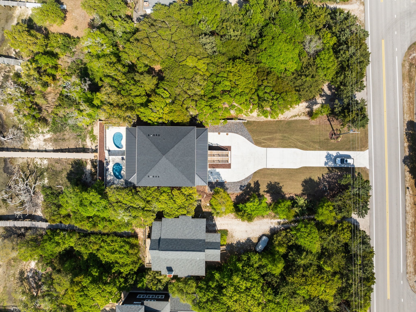 Aerial view of the vacation rental property surrounded by lush greenery, featuring a swimming pool and spacious outdoor areas.