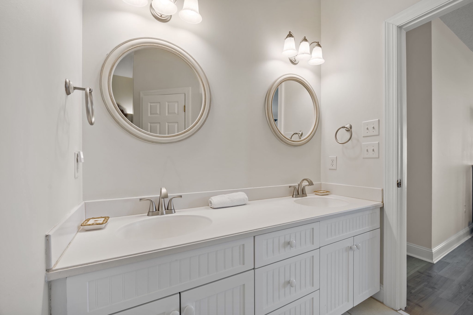 Refresh in your elegant dual-vanity bathroom with gleaming mirrors and crisp white cabinetry—perfect for sharing your morning routine.