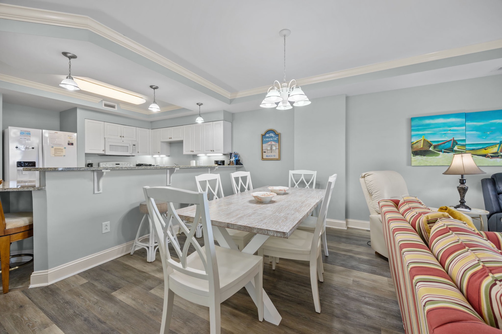 Your open-plan kitchen and dining area features crisp white cabinetry, granite counters, and a welcoming table perfect for shared meals.