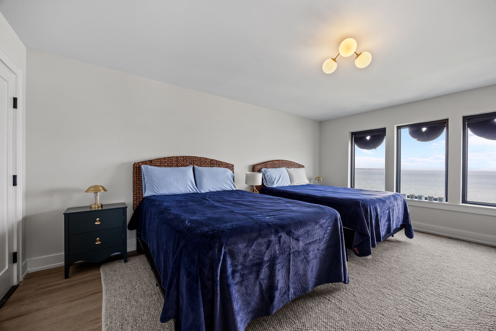 Wake up to stunning ocean views from your comfortable twin beds with coastal-inspired wicker headboards and plush navy bedding.