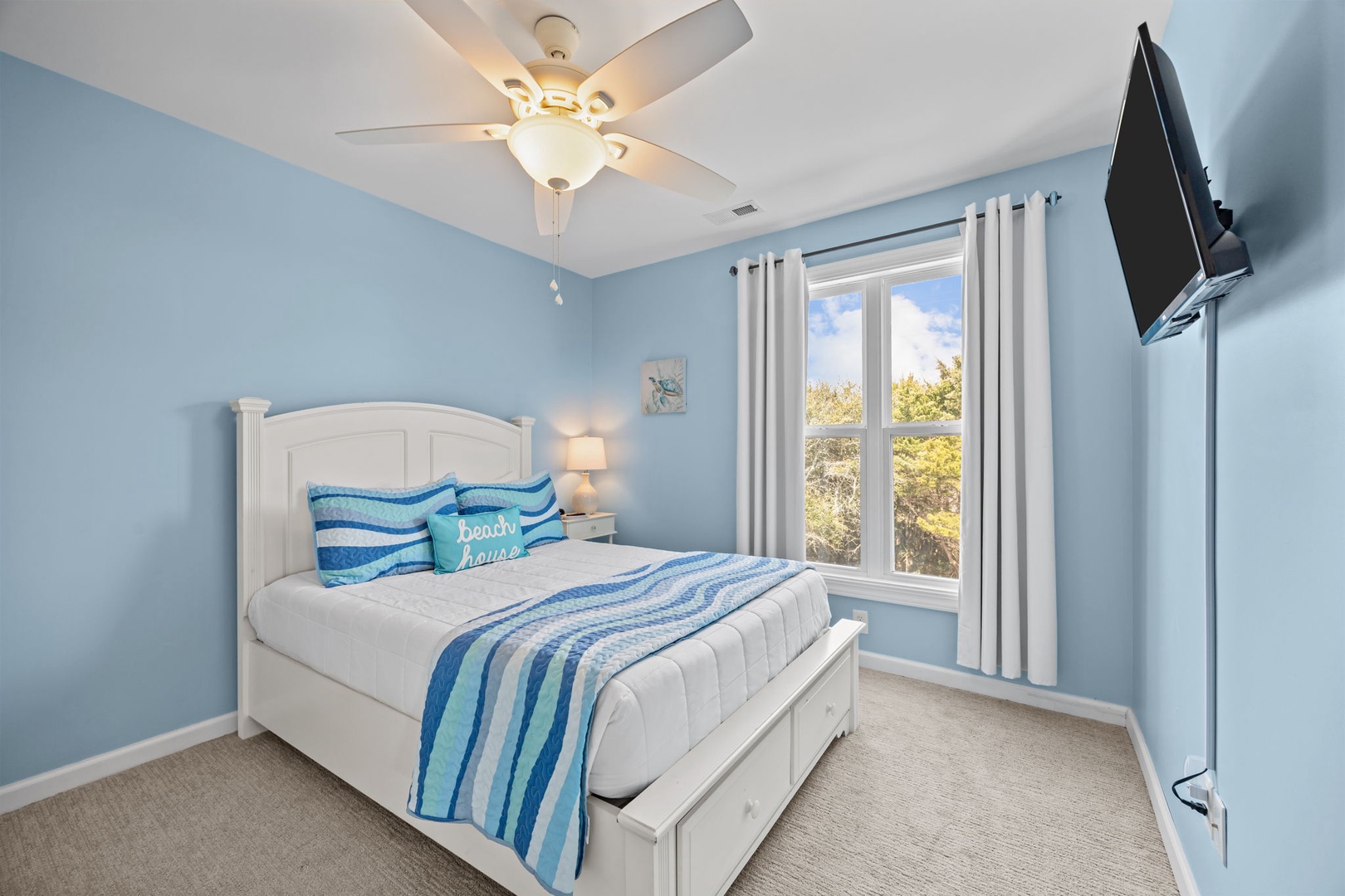 Drift off in this serene coastal bedroom with tranquil blue tones, comfortable bedding, and natural light streaming through your window.