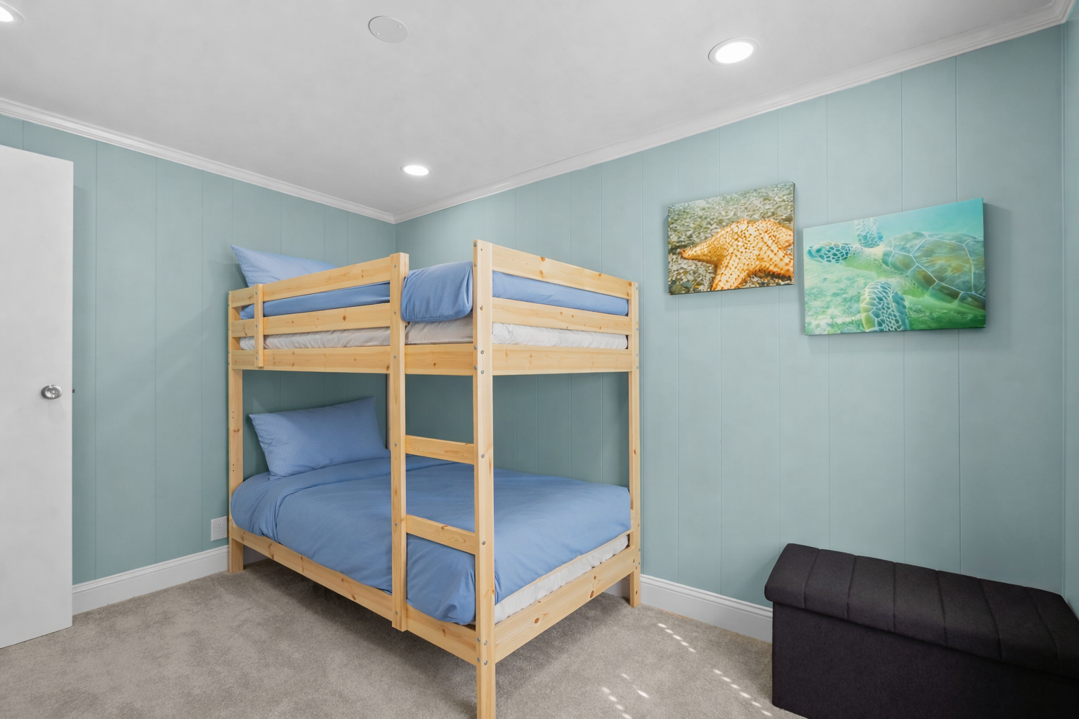 Your kids will love this cheerful bunk bed room with ocean-themed artwork and soft blue linens for cozy nights.