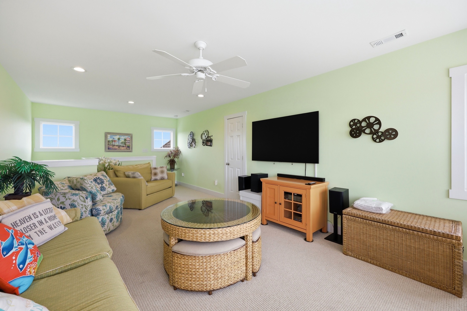 Your bright, cheerful living room invites you to unwind with comfortable seating, tropical touches, and entertainment ready for movie nights or game days after beach adventures.