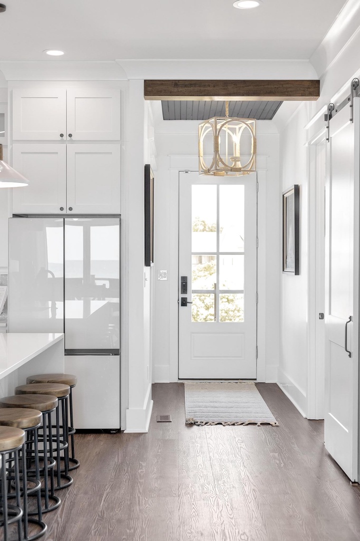 Step into a bright, modern kitchen with farmhouse charm, where crisp white cabinetry, warm wood beams, and gleaming appliances await your culinary adventures.
