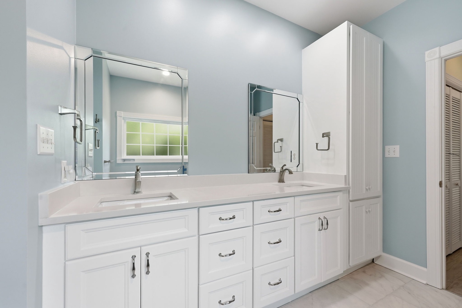 Pamper yourself in this spa-like bathroom with dual vanities, sleek white cabinetry, and abundant storage—your personal oasis awaits.
