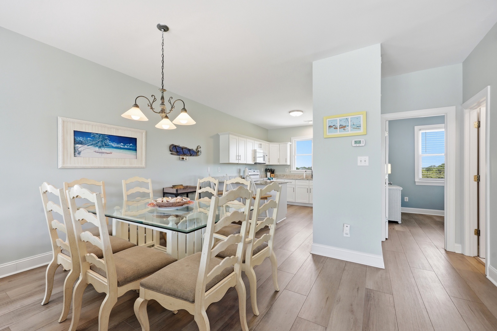 Gather around this inviting dining table for meals with loved ones. The bright open kitchen and coastal decor create a relaxed, beach-inspired atmosphere you'll love coming home to.