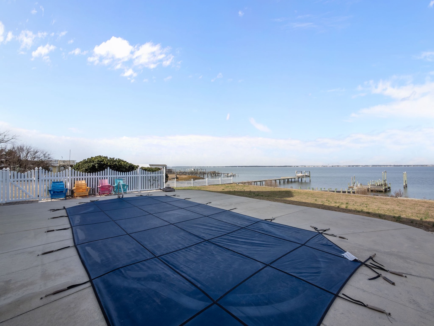 Waterfront property with covered pool overlooking peaceful bay waters and private docks for scenic coastal relaxation.