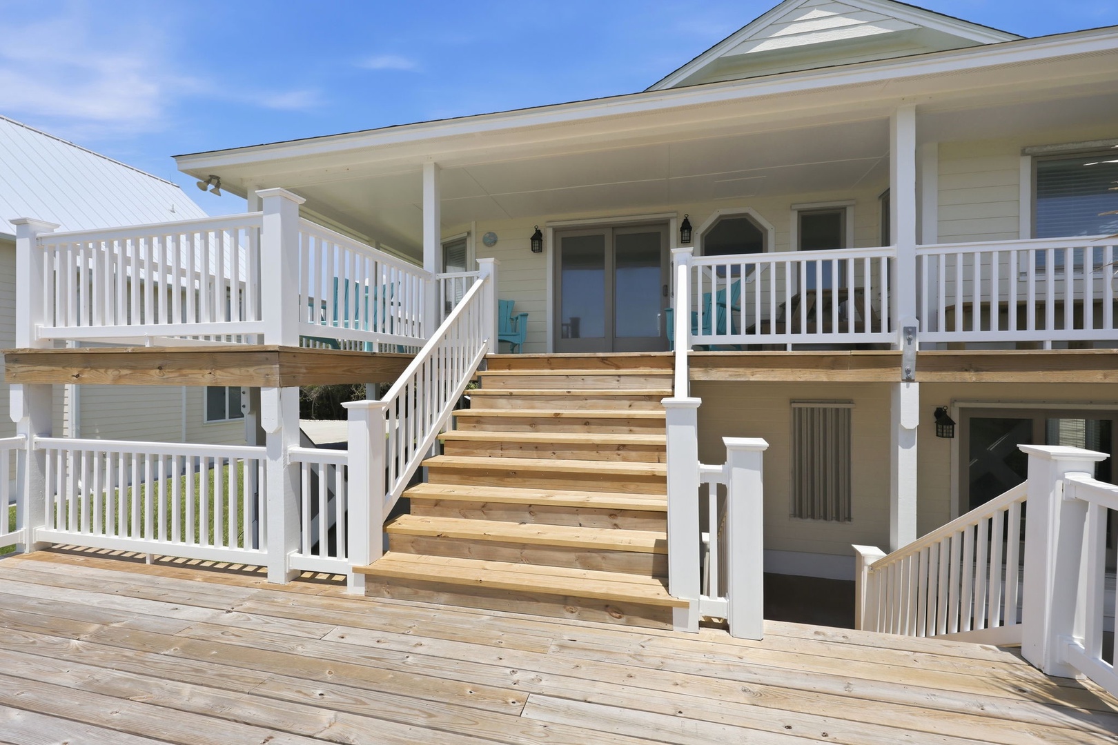 A spacious multi-level deck with covered porch overlooking the coastal area, offering outdoor living and scenic surroundings for the property.