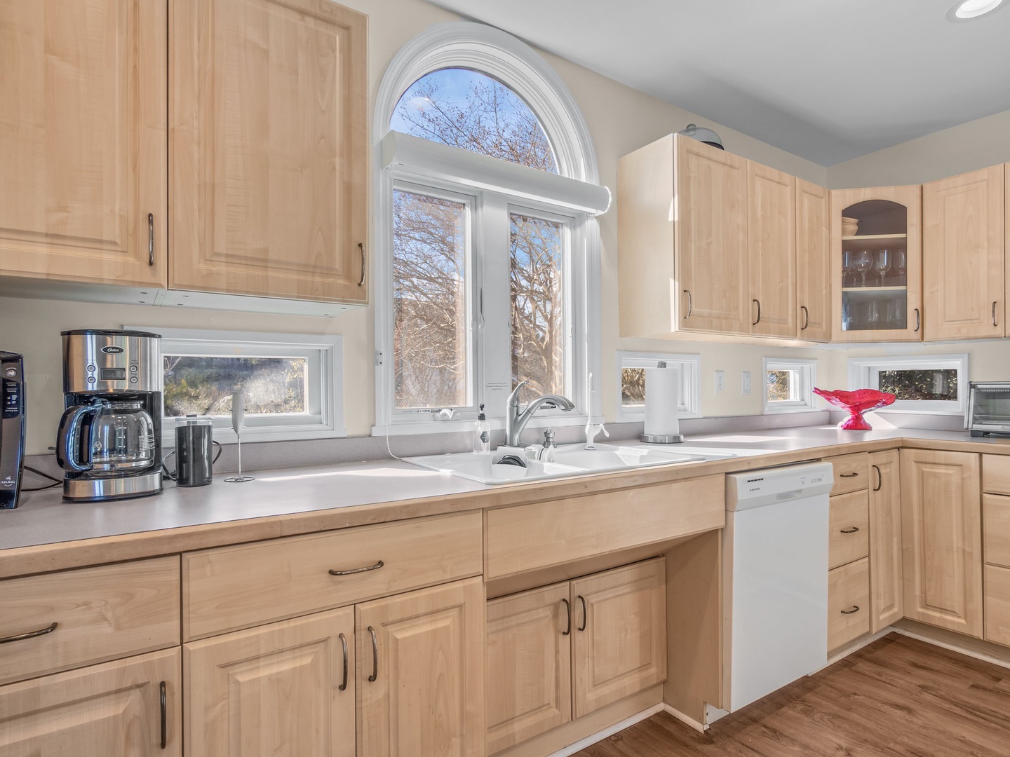 Cook your favorite meals in this fully equipped kitchen with natural maple cabinetry, modern appliances, and beautiful arched windows.