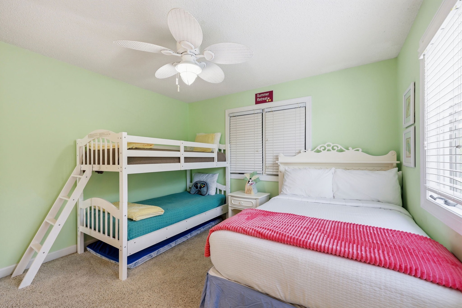 Your bright, cheerful bedroom features a cozy queen bed and a bunk bed, perfect for families. Crisp white linens, a ceiling fan, and playful pops of color create a welcoming retreat.