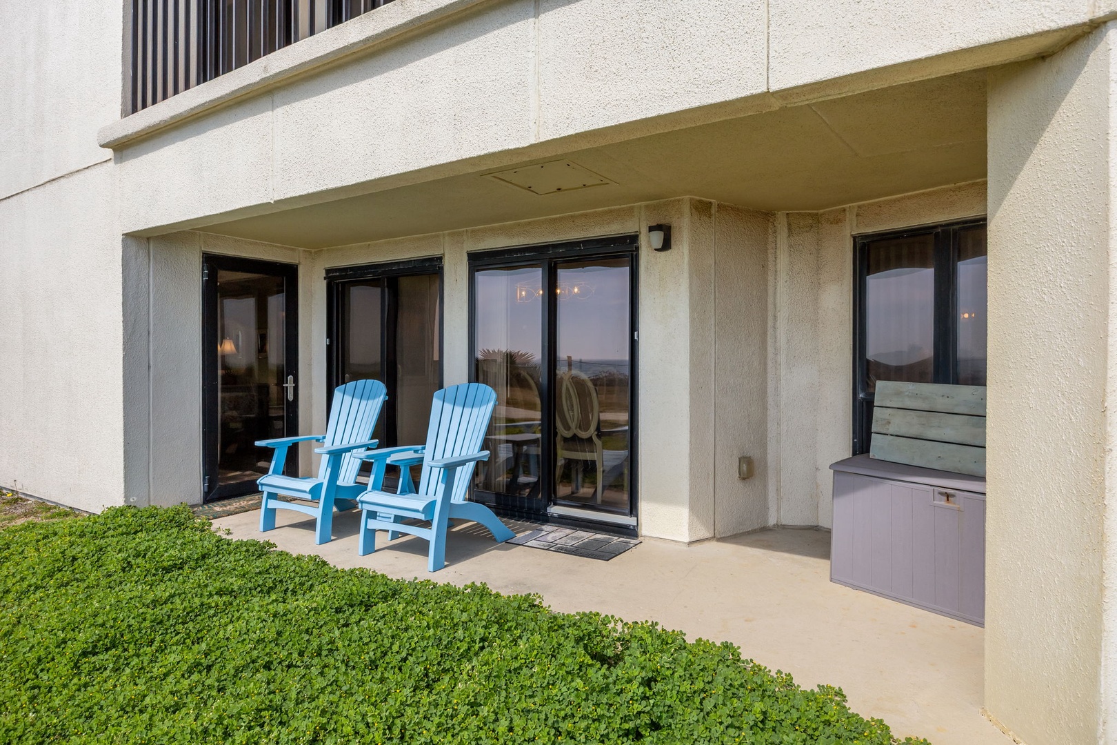 Relax in your bright blue Adirondack chairs on your private patio, where glass doors open to reveal your peaceful coastal retreat.
