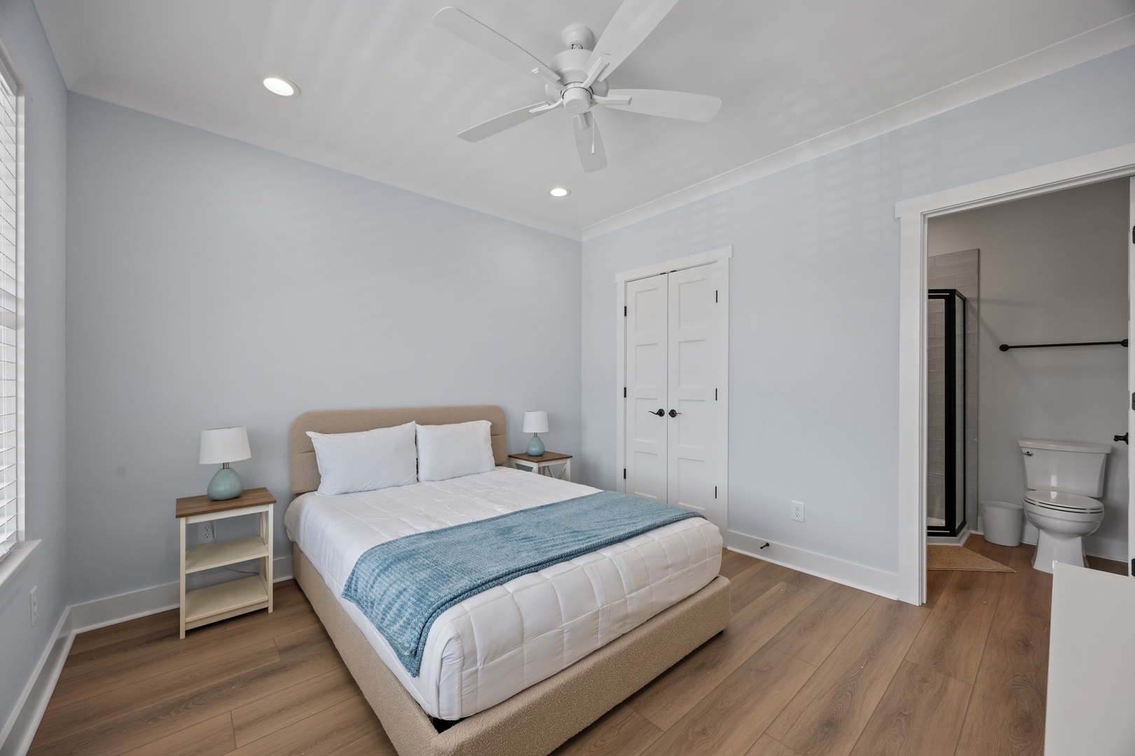 Sink into your cozy bed with soft linens and calming blue accents. The ceiling fan keeps you comfortable while ensuite convenience awaits.