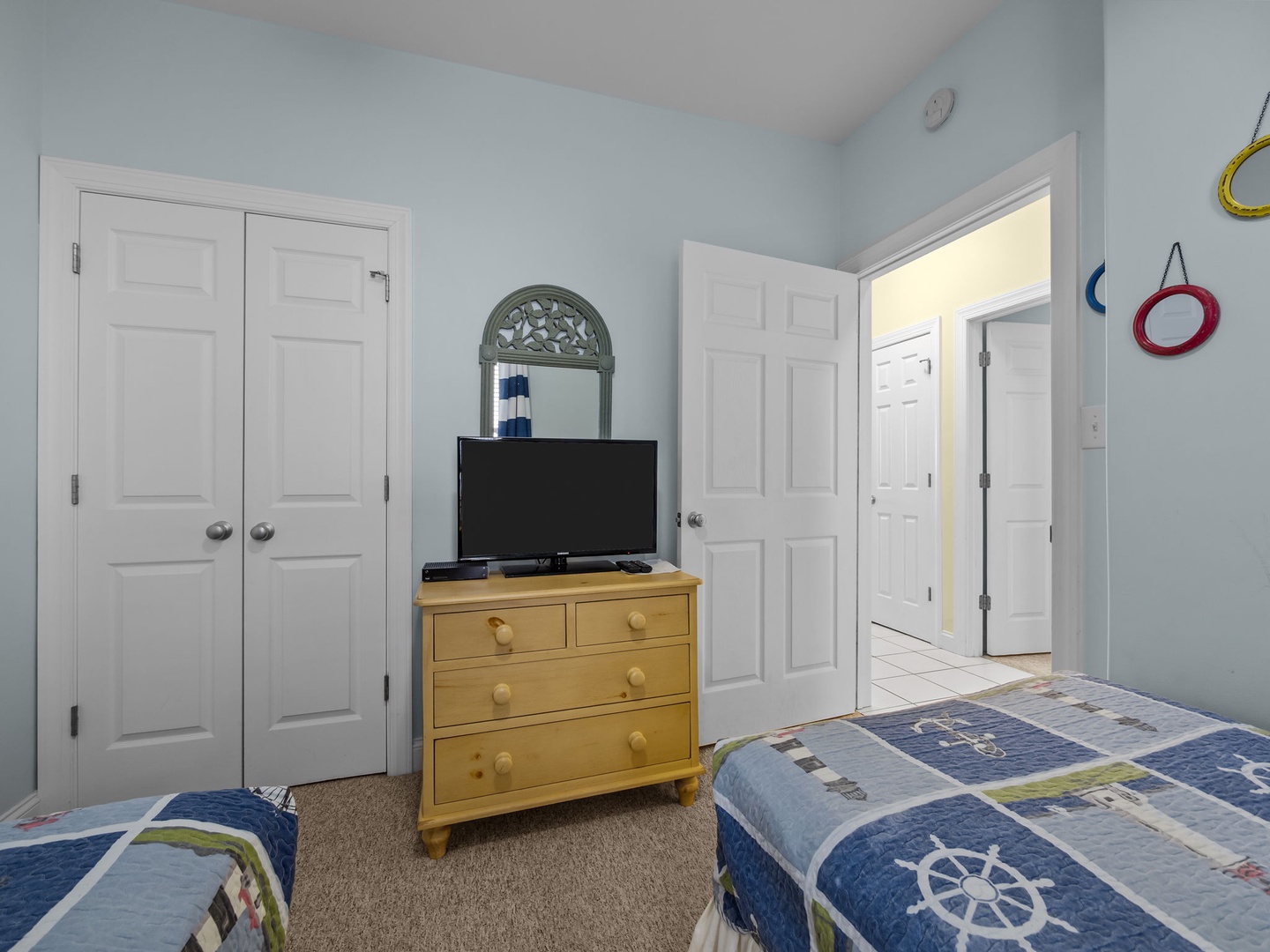 Your coastal bedroom features twin beds with charming nautical bedding and convenient entertainment setup for relaxing evenings.