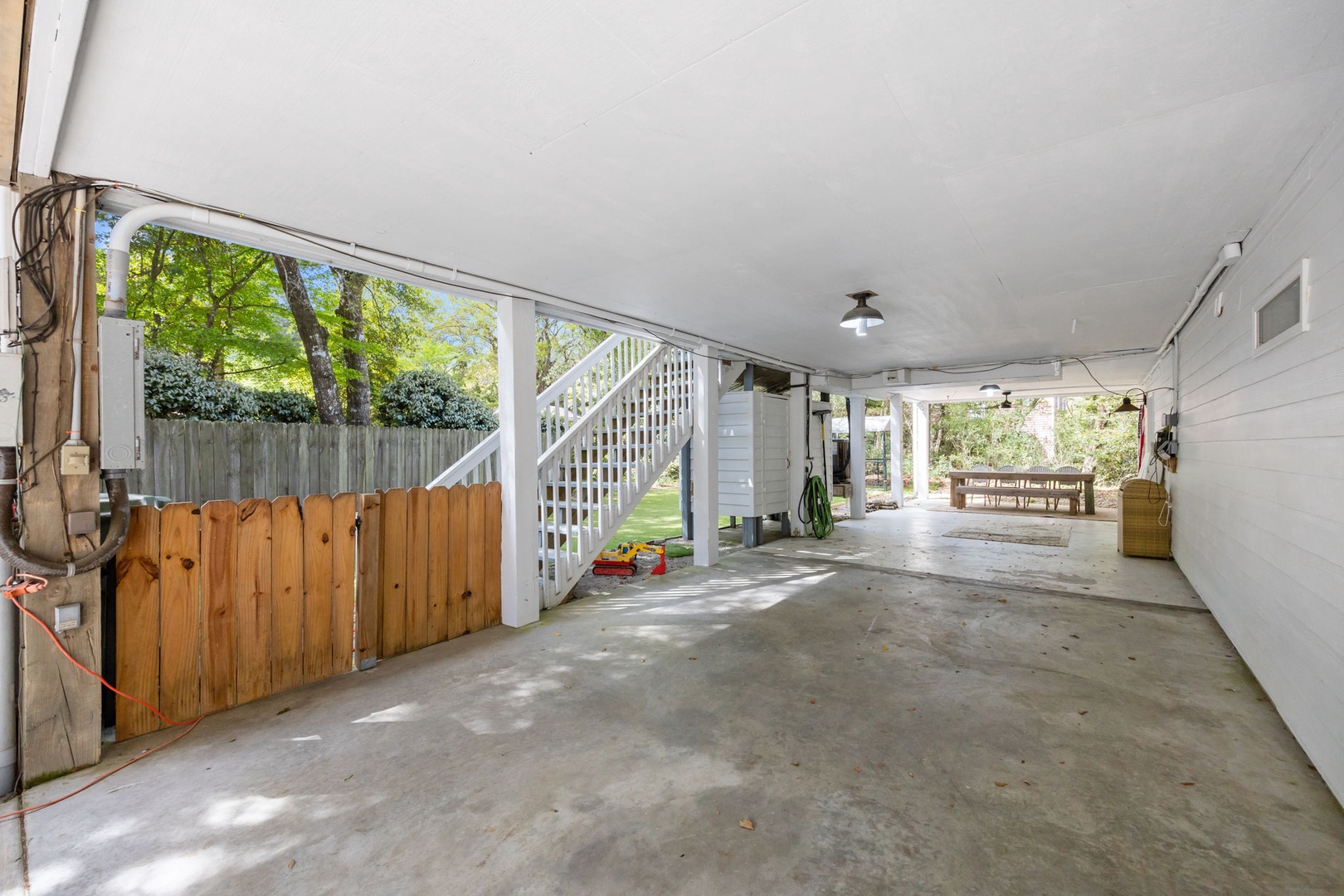 Your covered parking area provides secure vehicle storage with convenient access to your upstairs accommodation and peaceful garden views.