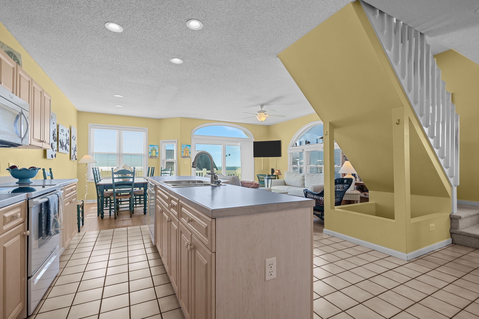 Your spacious kitchen island becomes the heart of family gatherings, with ocean views streaming through the windows as you prepare meals together.