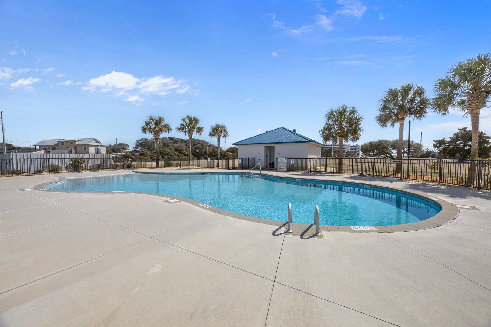 Crystal-clear community pool surrounded by palm trees under Florida's endless blue sky.
