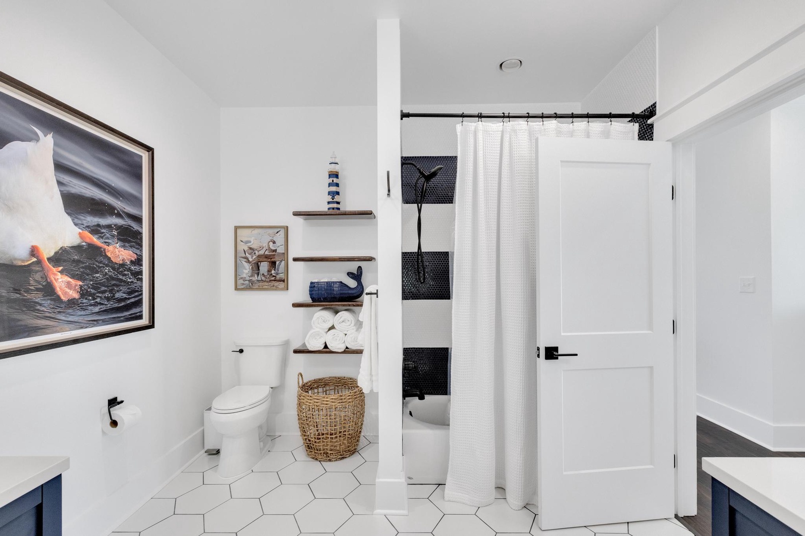 Crisp white tiles and nautical touches create a bright, refreshing retreat. Notice the thoughtful storage and classic style that make your stay effortless.