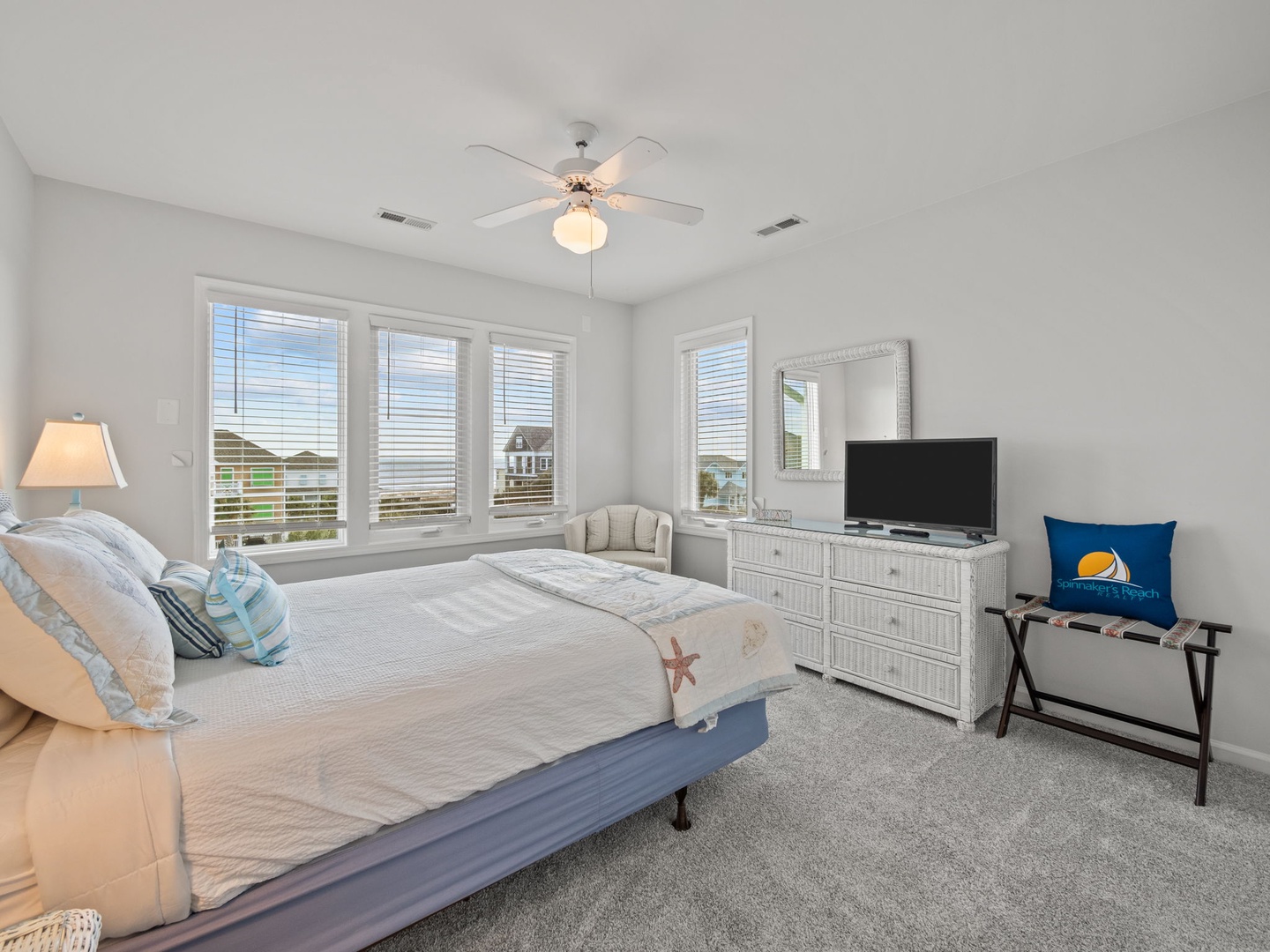 Drift off to sleep in your coastal-themed bedroom with ocean views through bright windows, complete with TV for your comfort.