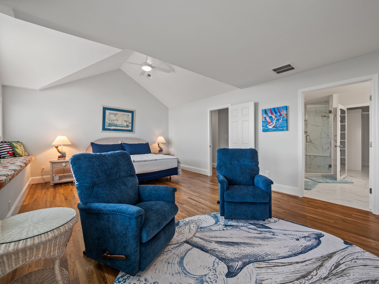 Your spacious bedroom suite features two cozy blue recliners where you can unwind, beautiful hardwood floors, and an elegant ensuite bathroom.
