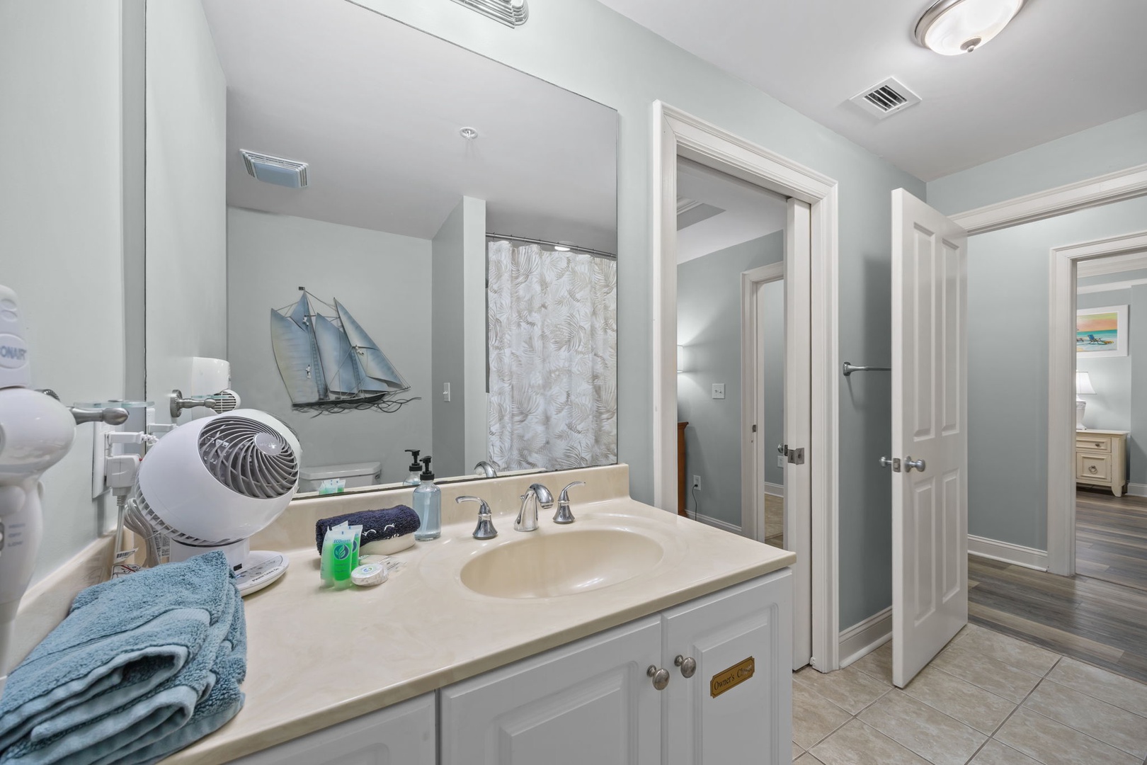 Refresh in this elegant bathroom with modern amenities and coastal touches, featuring a spacious vanity and convenient hair dryer for your comfort.