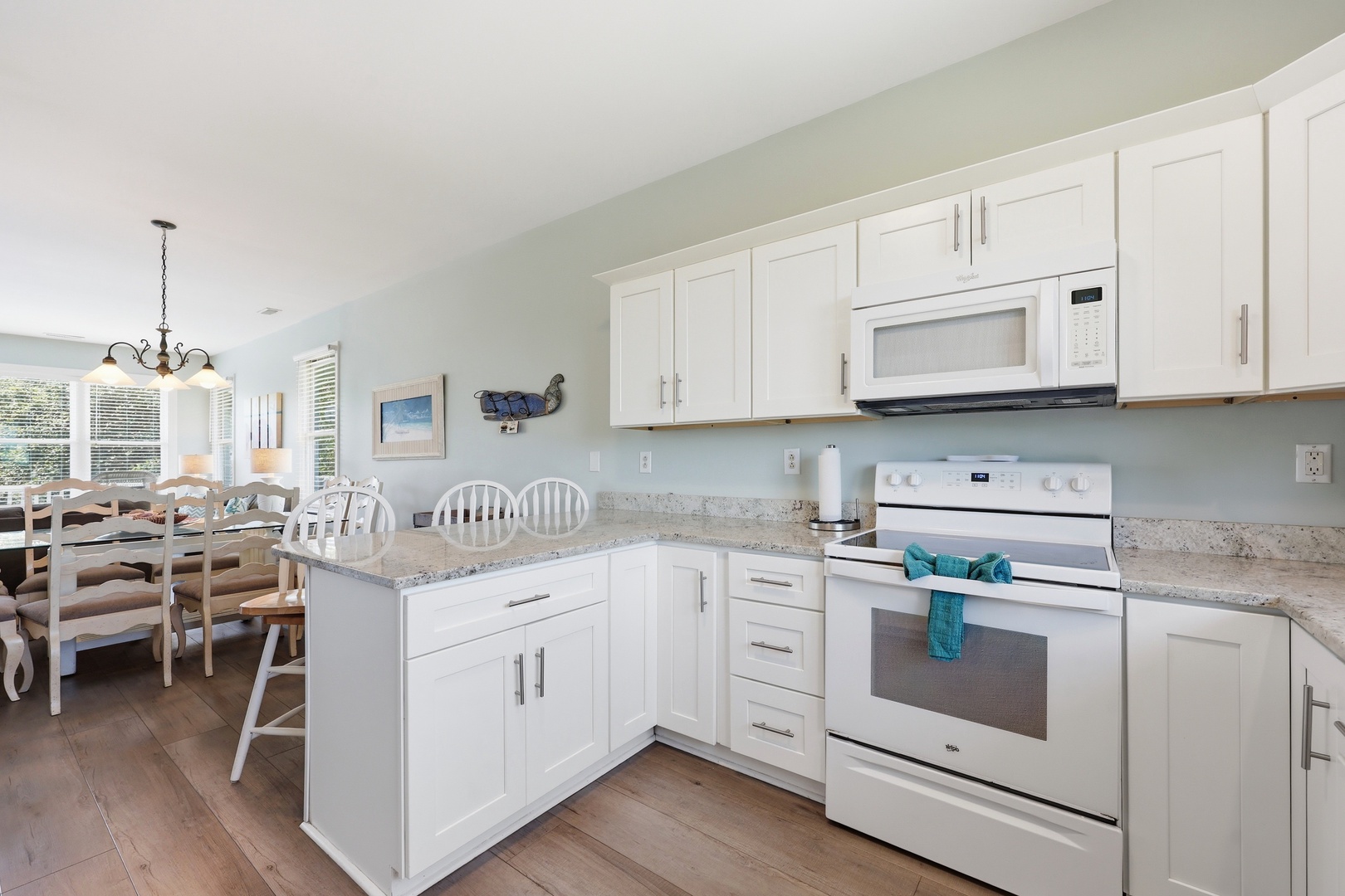 Step into your bright, open-concept kitchen with white cabinetry, granite countertops, and all the appliances you need to whip up your favorite meals. The adjoining dining space makes gathering with loved ones effortless and inviting.
