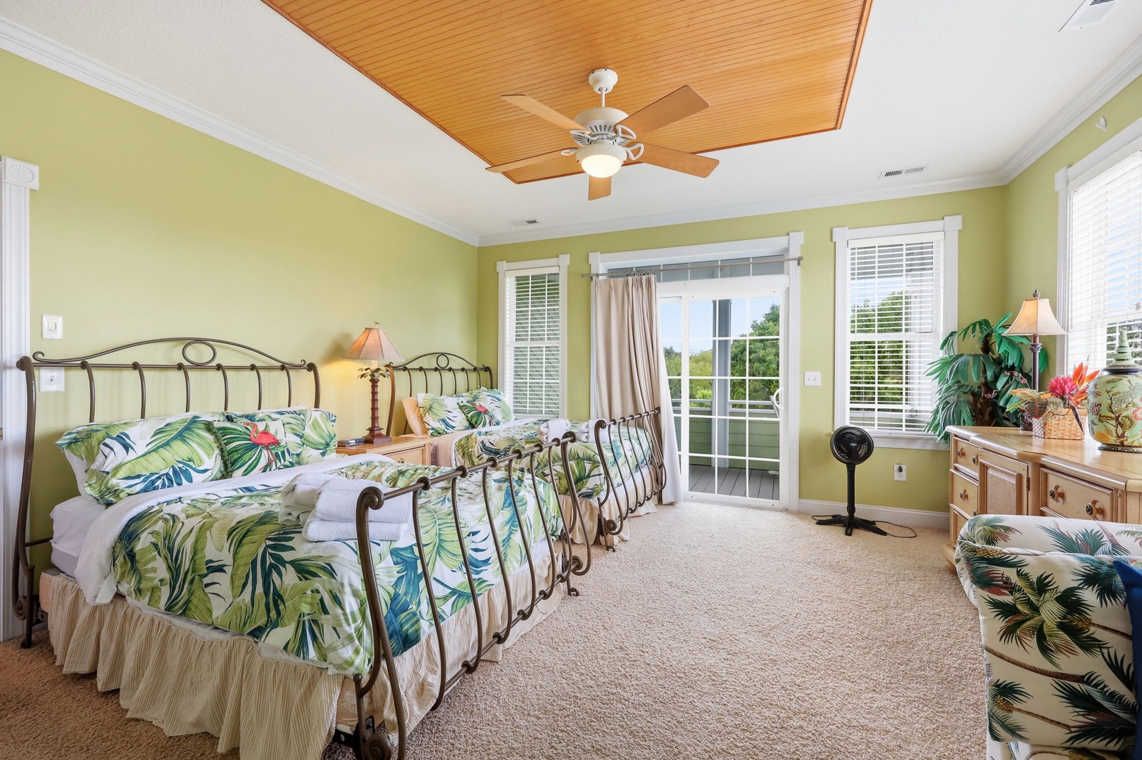 Wake up in your tropical-themed bedroom with botanical bedding and warm wood ceiling. French doors lead to your private patio, blending indoor comfort with outdoor charm.