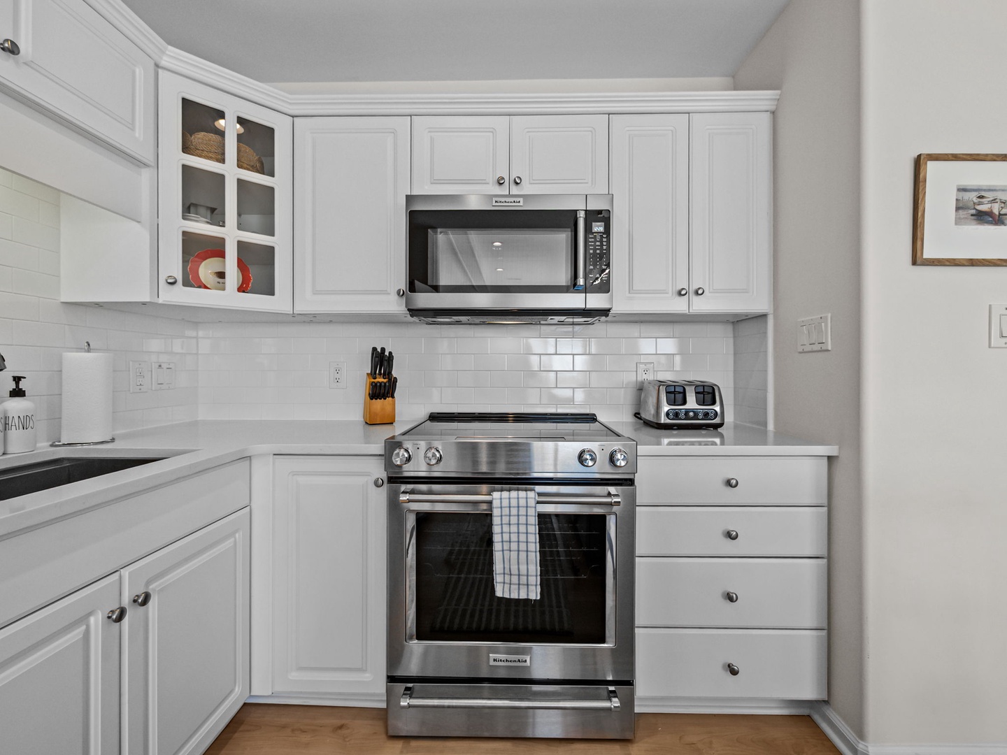 Cook your favorite meals in this bright, fully-equipped kitchen with stainless steel appliances and classic white cabinetry.