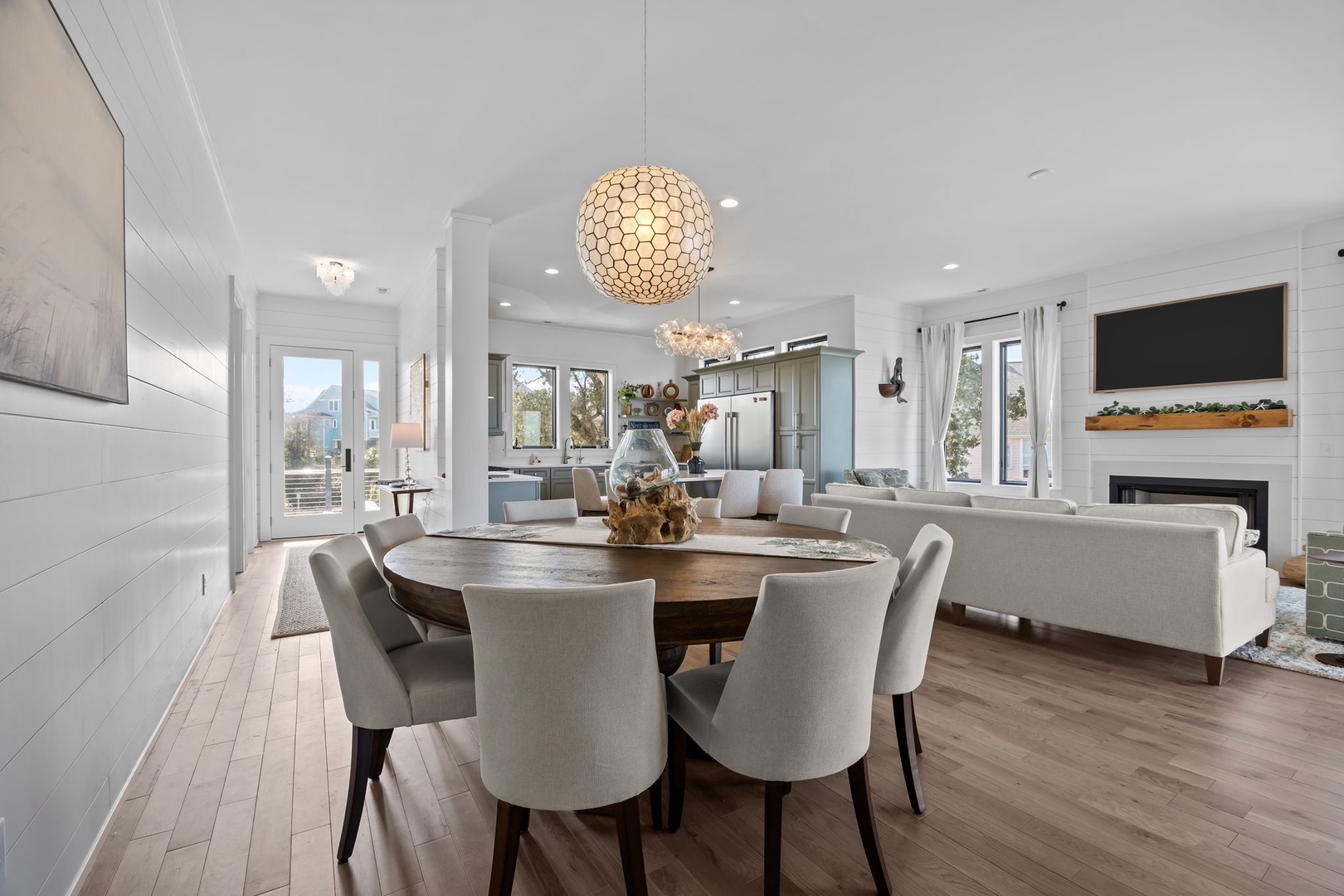You'll love gathering around this elegant round dining table while enjoying the open-concept living space with stunning pendant lighting.