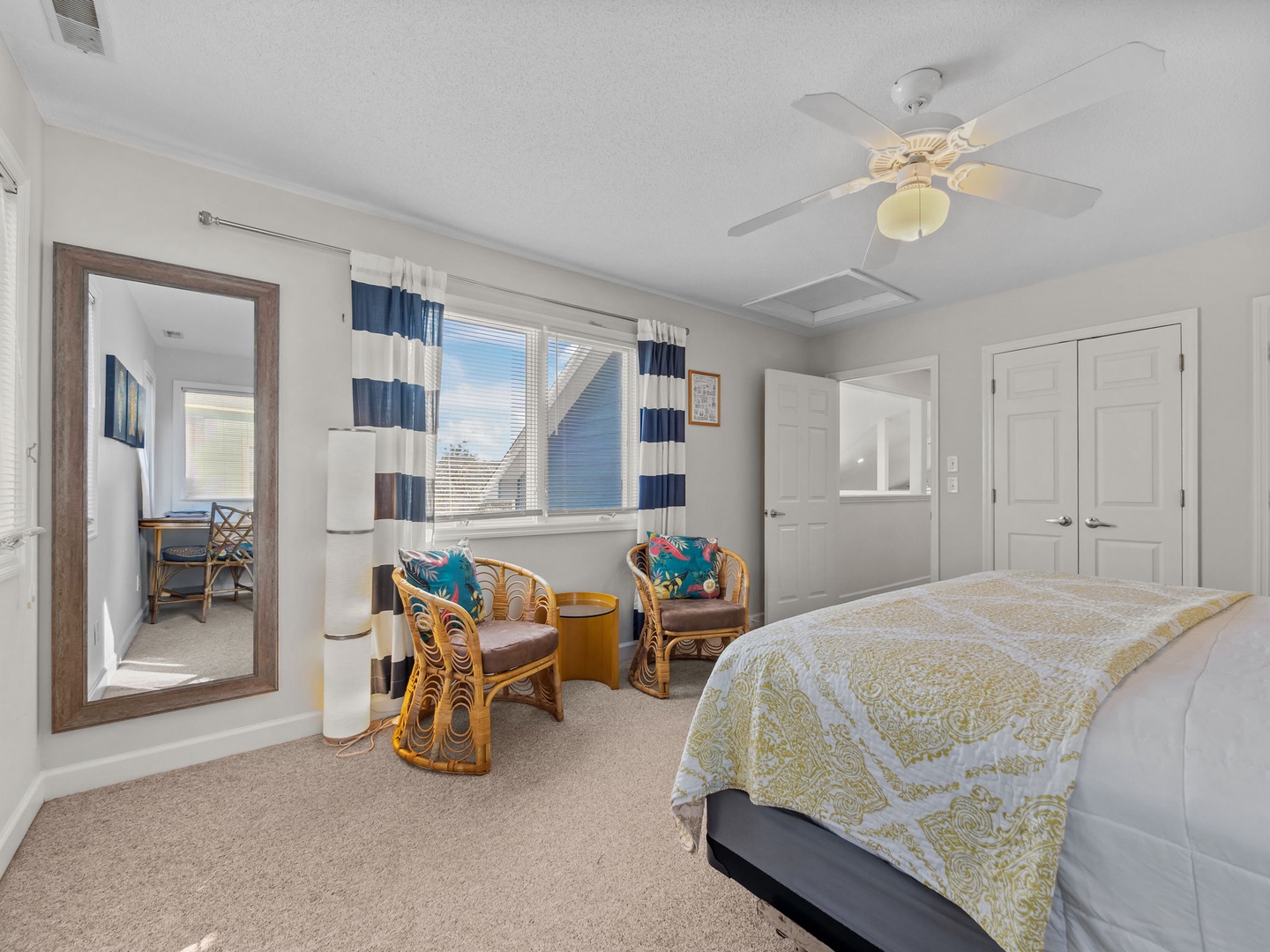 Relax in your bright coastal bedroom with tropical wicker seating, nautical curtains, and city views through oversized windows.