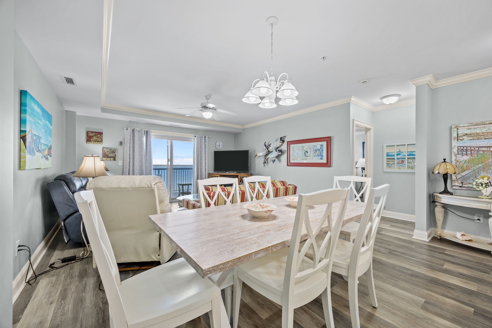 Step into your bright, coastal-themed living space where ocean views frame memorable meals around the elegant dining table.