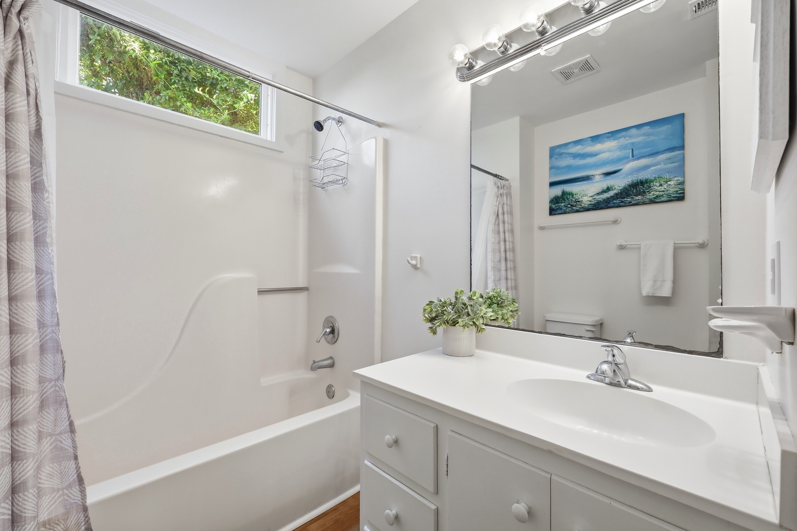 Freshen up in your bright, clean bathroom with a deep soaking tub, fresh towels, and serene coastal artwork to help you unwind after a day of exploring.