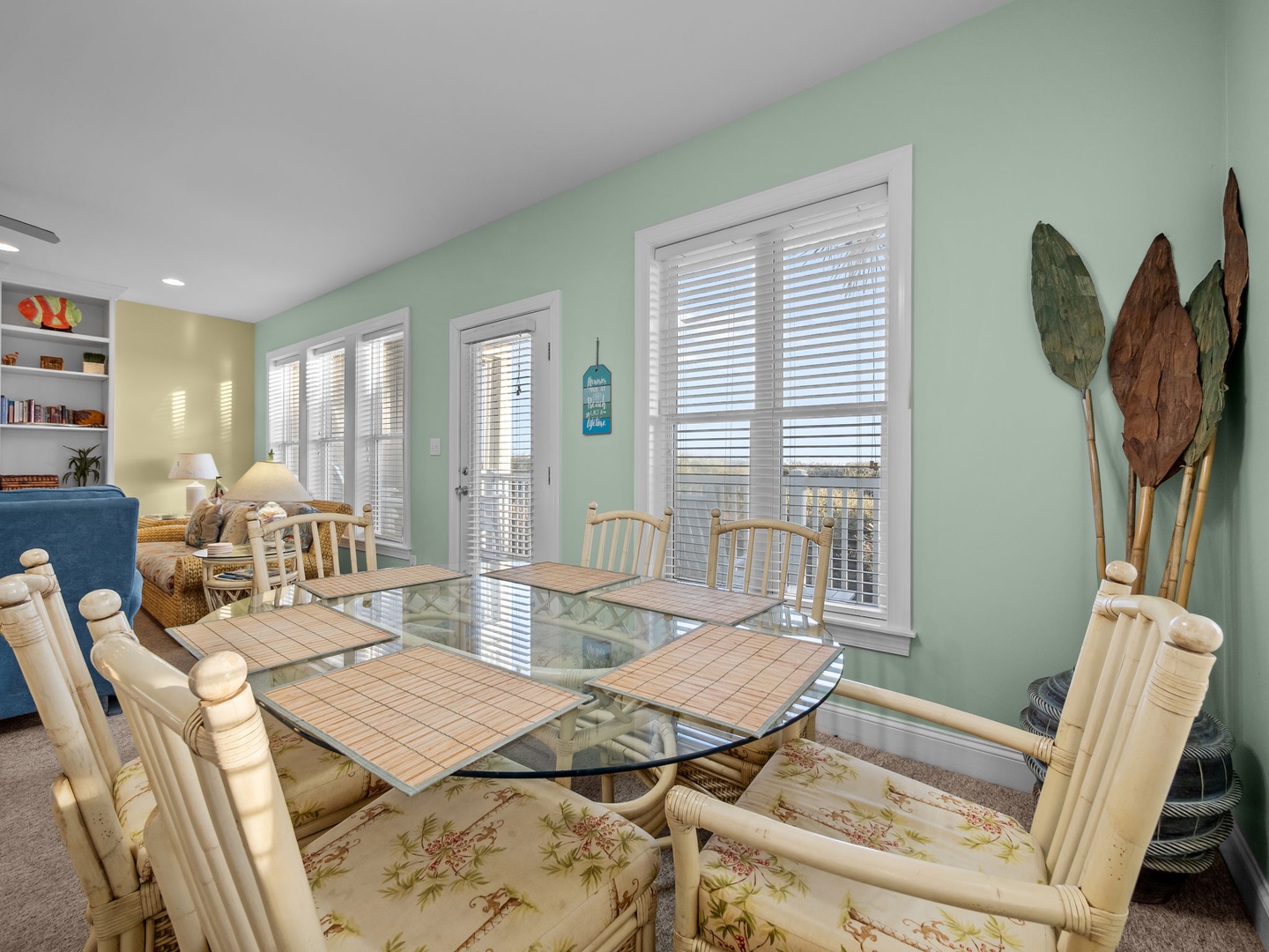Gather around this coastal-inspired dining space where bamboo chairs and tropical decor create the perfect setting for memorable meals together.
