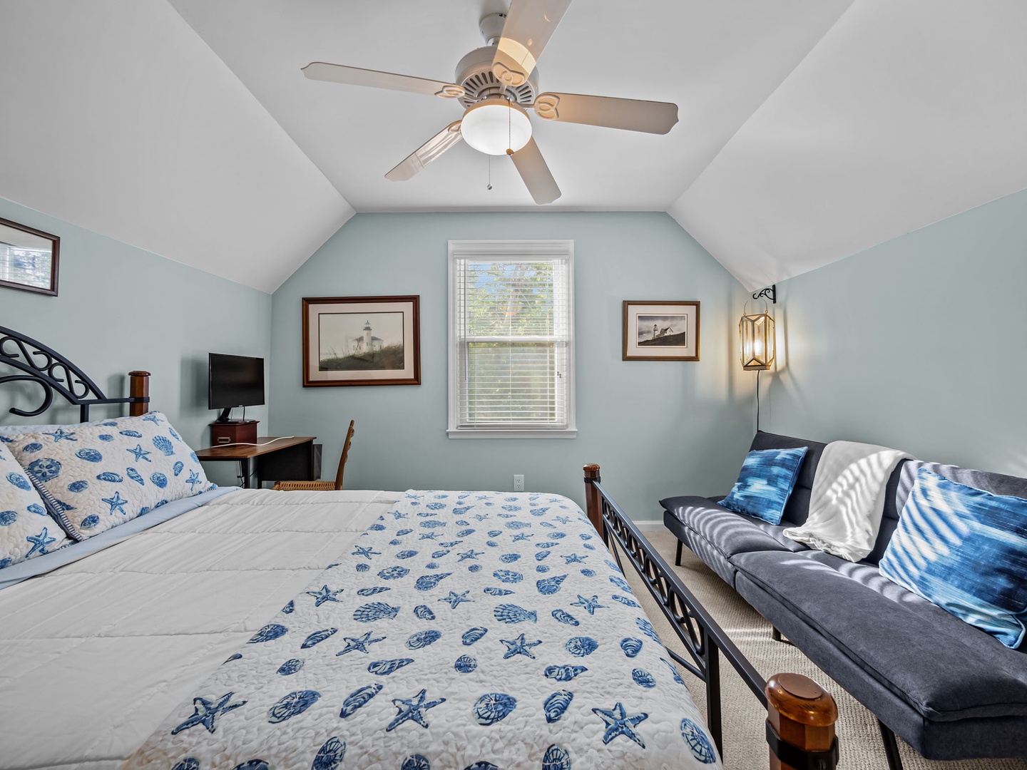 Your coastal-themed bedroom features nautical linens, vaulted ceilings with ceiling fan, and comfy seating area for relaxing after beach days.