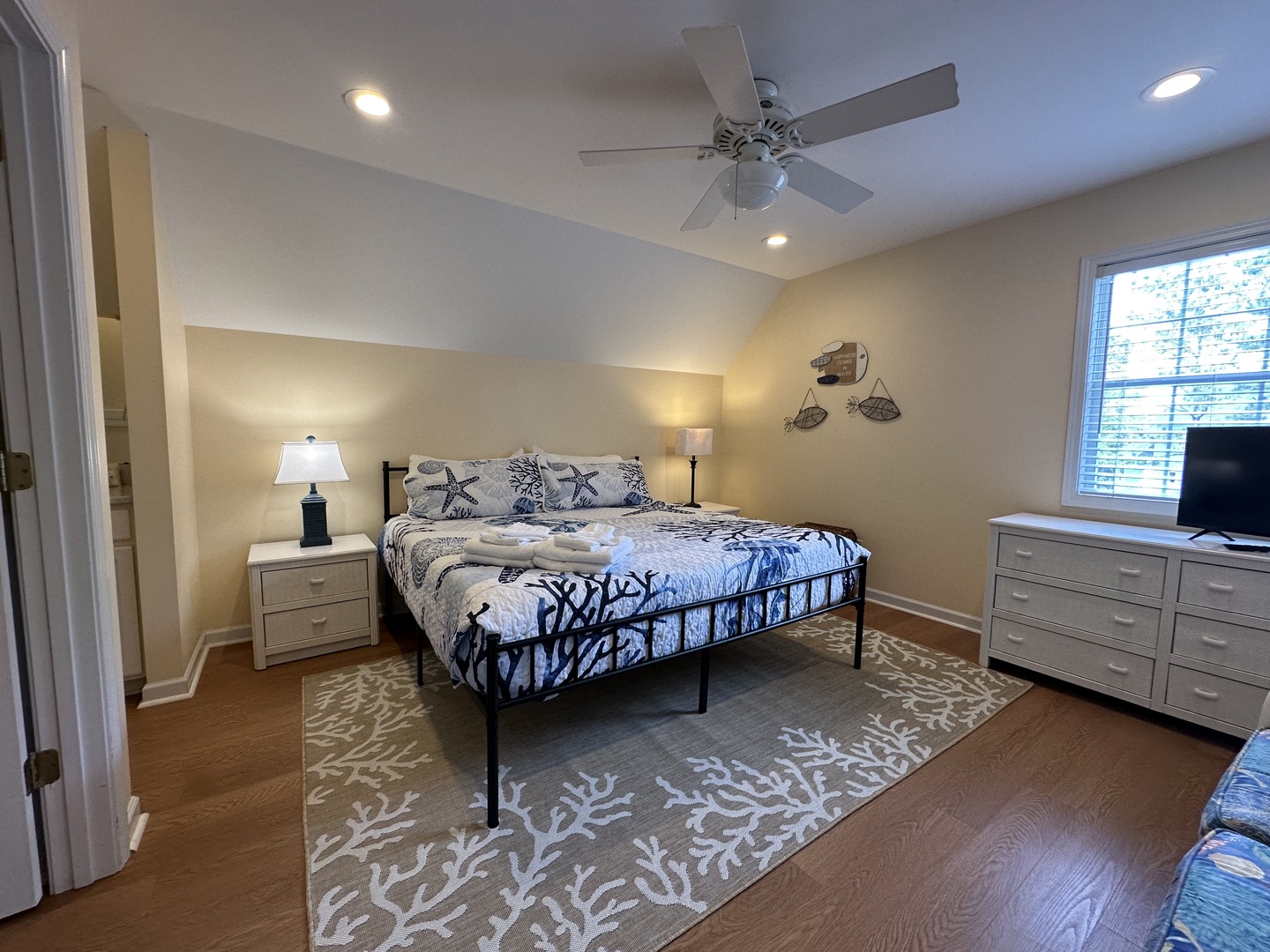 Relax in your serene bedroom with coastal charm. Soft bedding, soothing decor, and gentle ceiling fan breezes help you unwind after beach adventures.