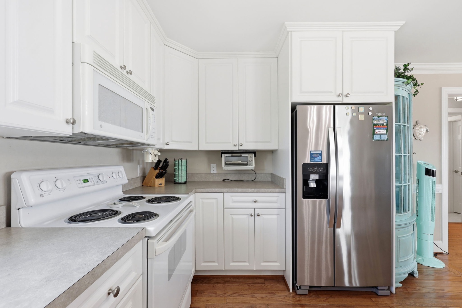 Your fully equipped kitchen features stainless steel appliances and bright white cabinetry, making meal prep feel effortless and welcoming.