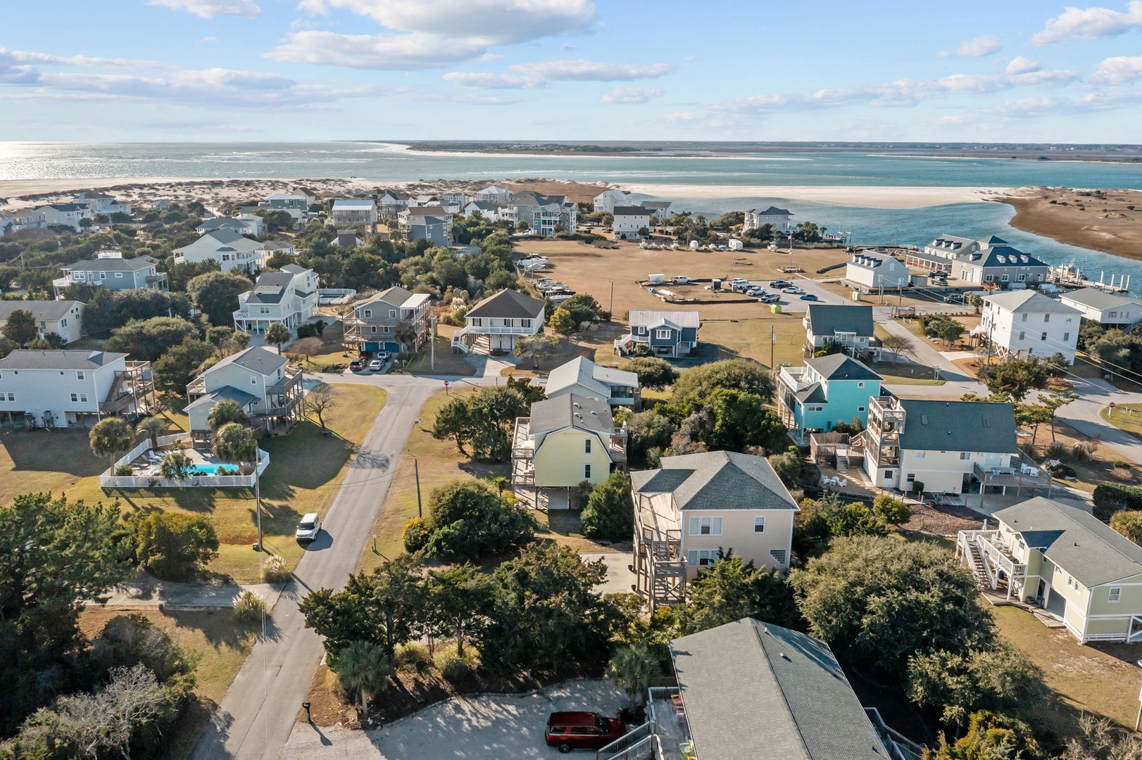 Stunning aerial view reveals a charming beach community with pristine shores and turquoise waters just steps away from comfortable coastal homes.