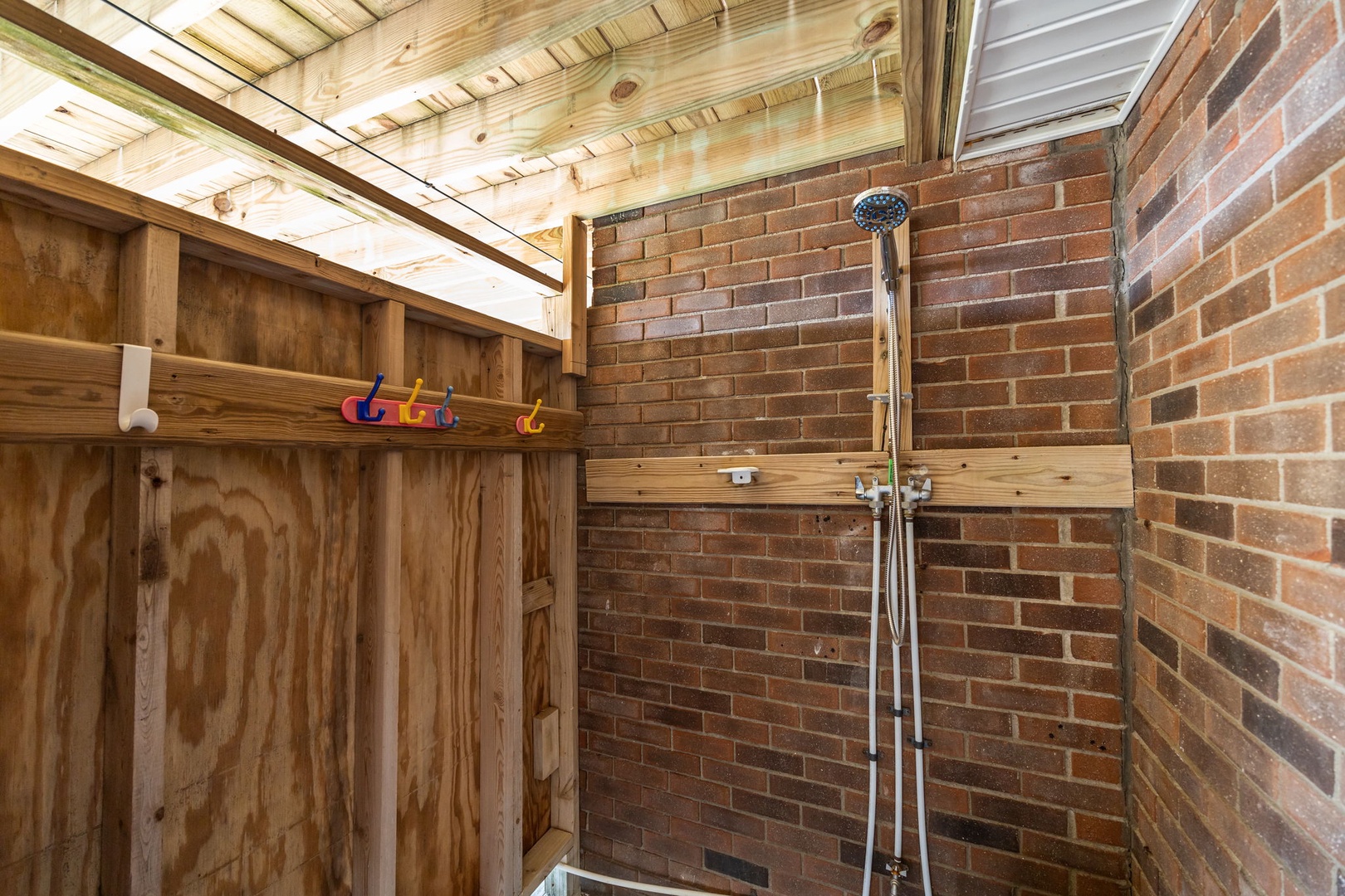 Rinse off under your private outdoor shower, surrounded by warm brick walls and natural wood—perfect after beach days or hikes.