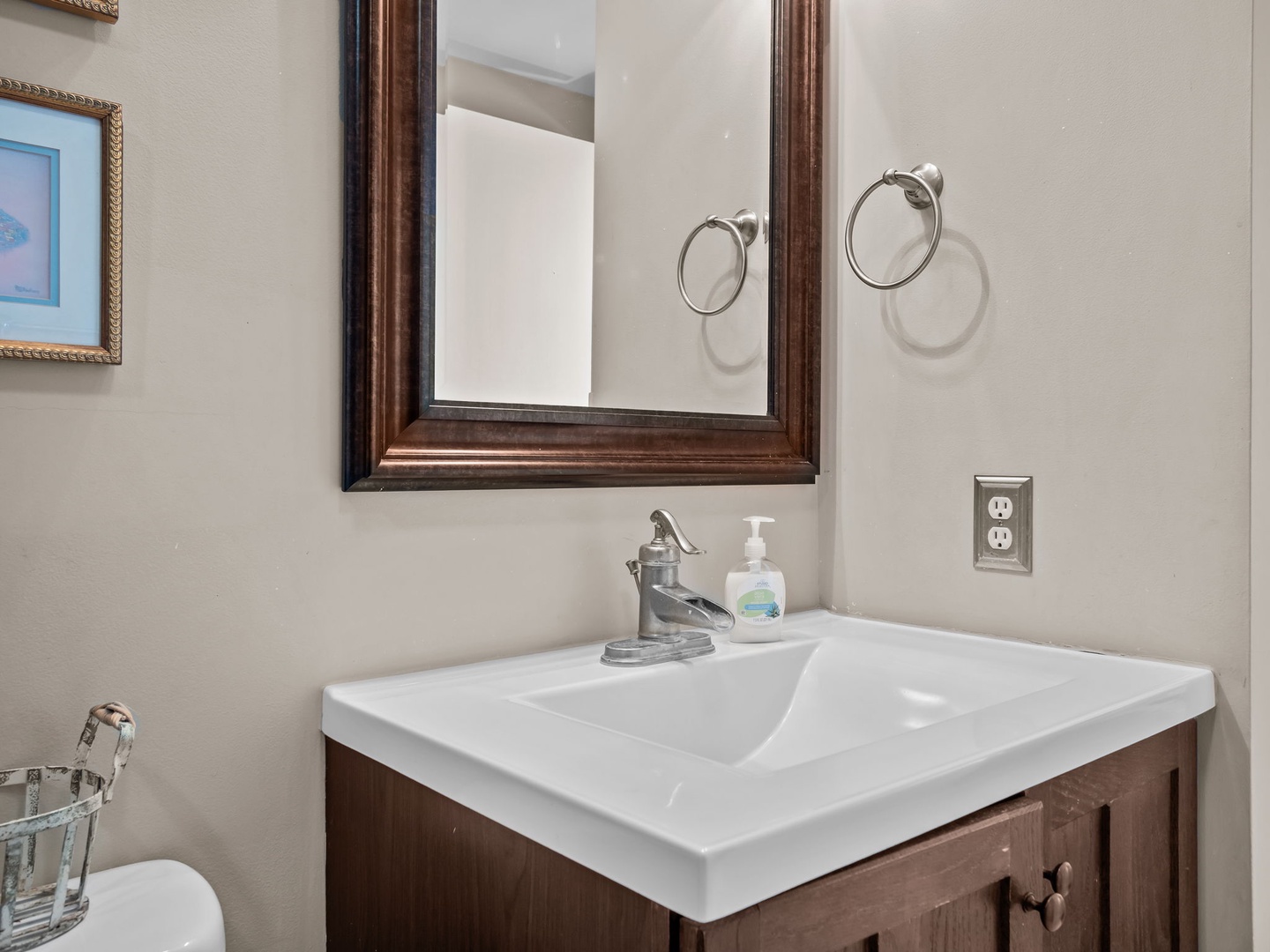Refresh in your private bathroom featuring a spacious vanity, elegant bronze-framed mirror, and thoughtful touches like complimentary soap.