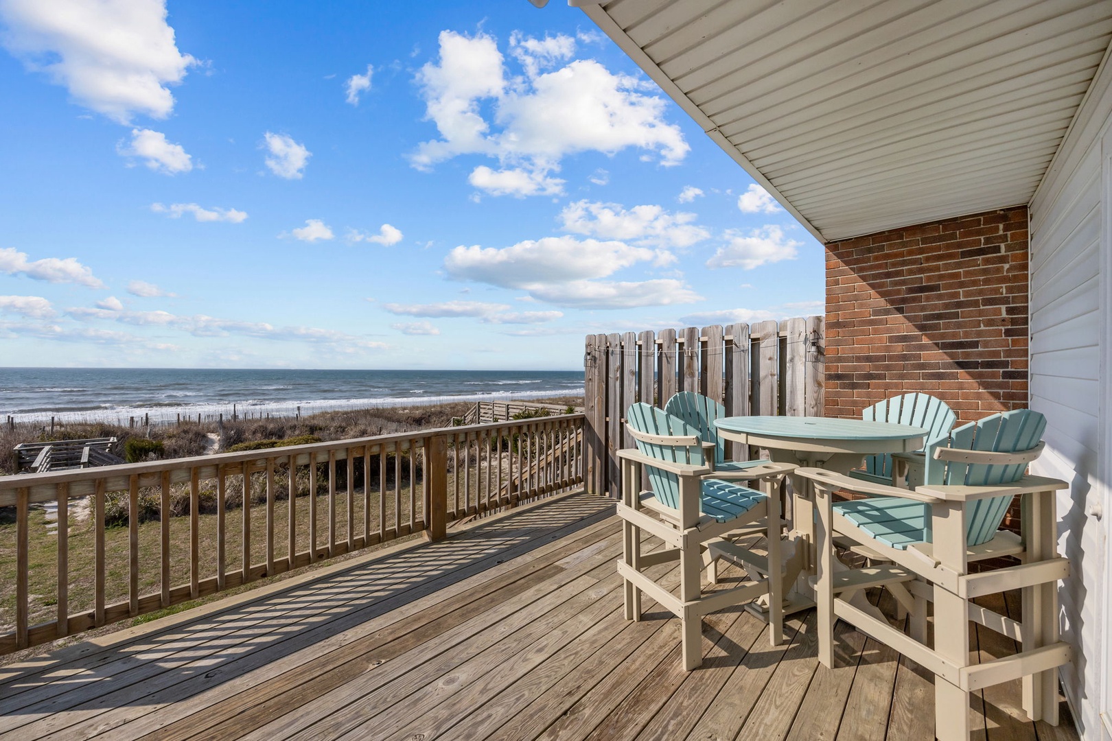 Your private deck overlooks pristine beach where ocean waves meet sandy shores, creating the perfect backdrop for morning coffee or sunset dining.