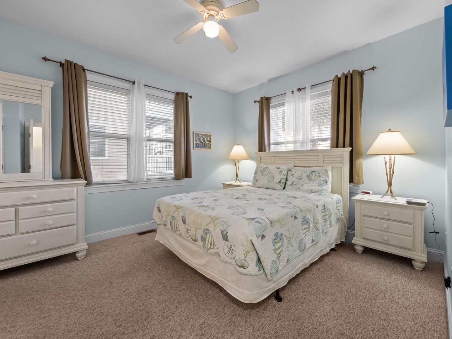 Your peaceful bedroom retreat features soft blue walls, elegant white furniture, and coastal-themed bedding to ensure you wake up refreshed.