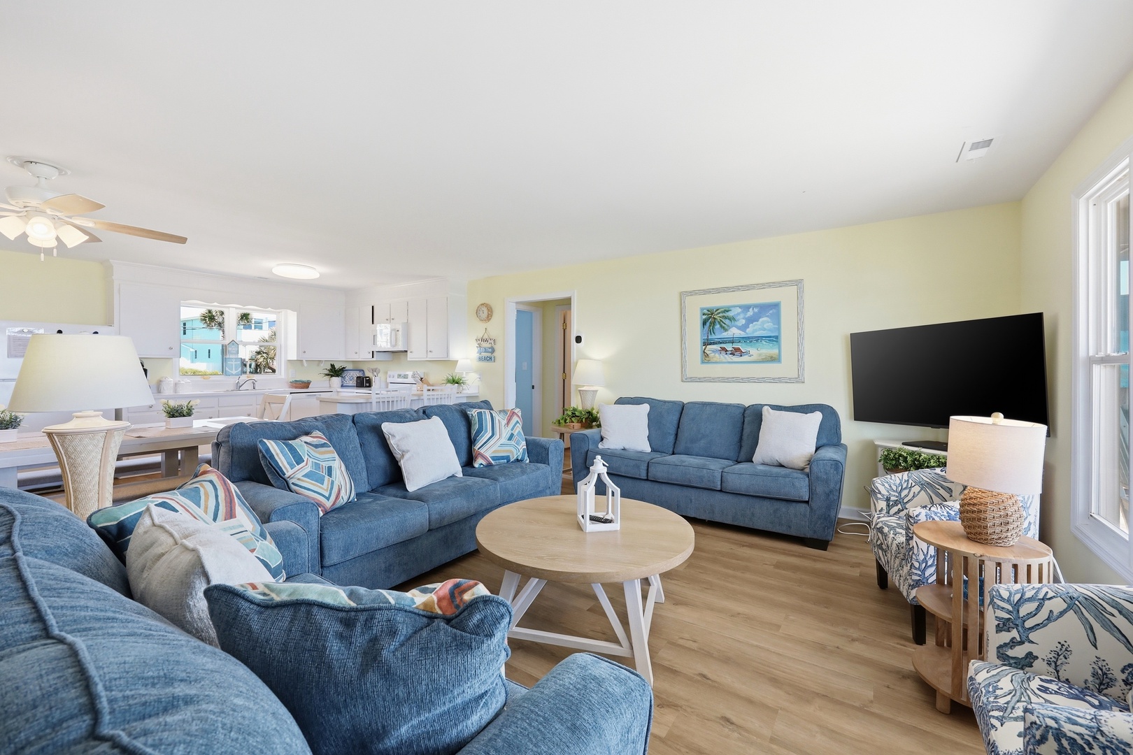 Sink into these plush blue sofas with your favorite book after a day of beach adventures. The open layout flows effortlessly into the kitchen and dining space, perfect for sharing meals and making memories together.