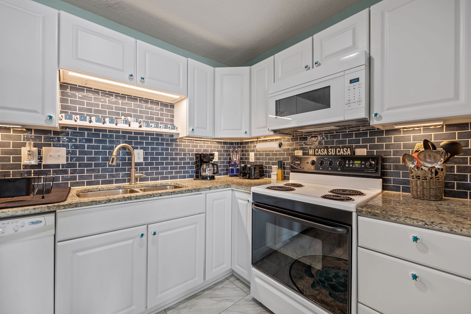 Your fully equipped kitchen awaits with granite countertops, stylish subway tile backsplash, and everything needed to create memorable meals.